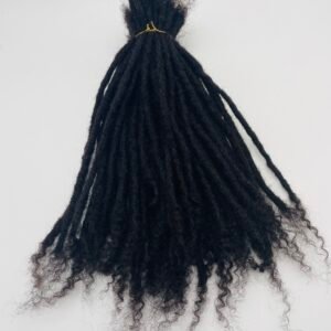 Back view of a person with long black dreadlocks gathered into a small top knot secured with a yellow hair tie on a light background.