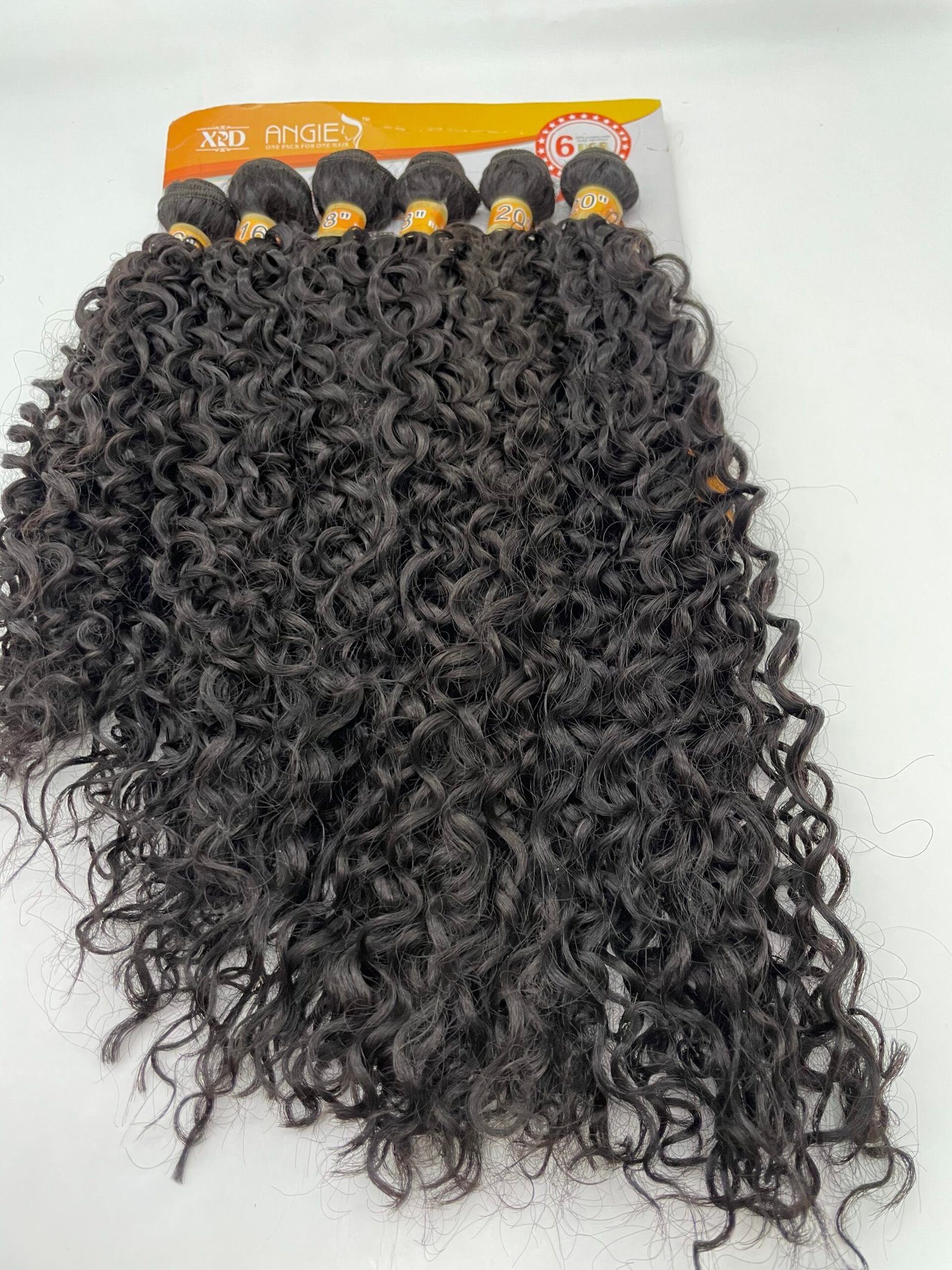 Dark, tight-curly hair extensions in a packaging card with an orange top edge and brand label visible at the top left.