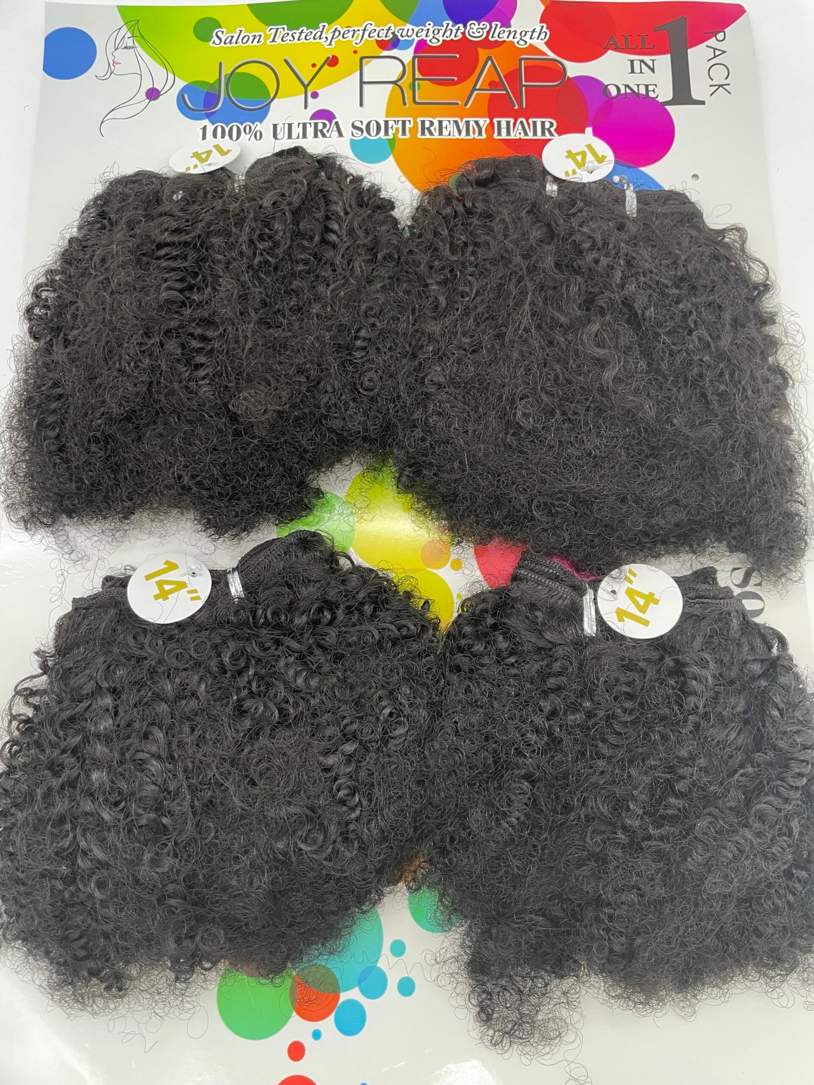 Several bundles of tight, black curly hair extensions laid on a bright, color-splashed display card featuring 'Joy Read' branding and '14"' labels before the hair ends