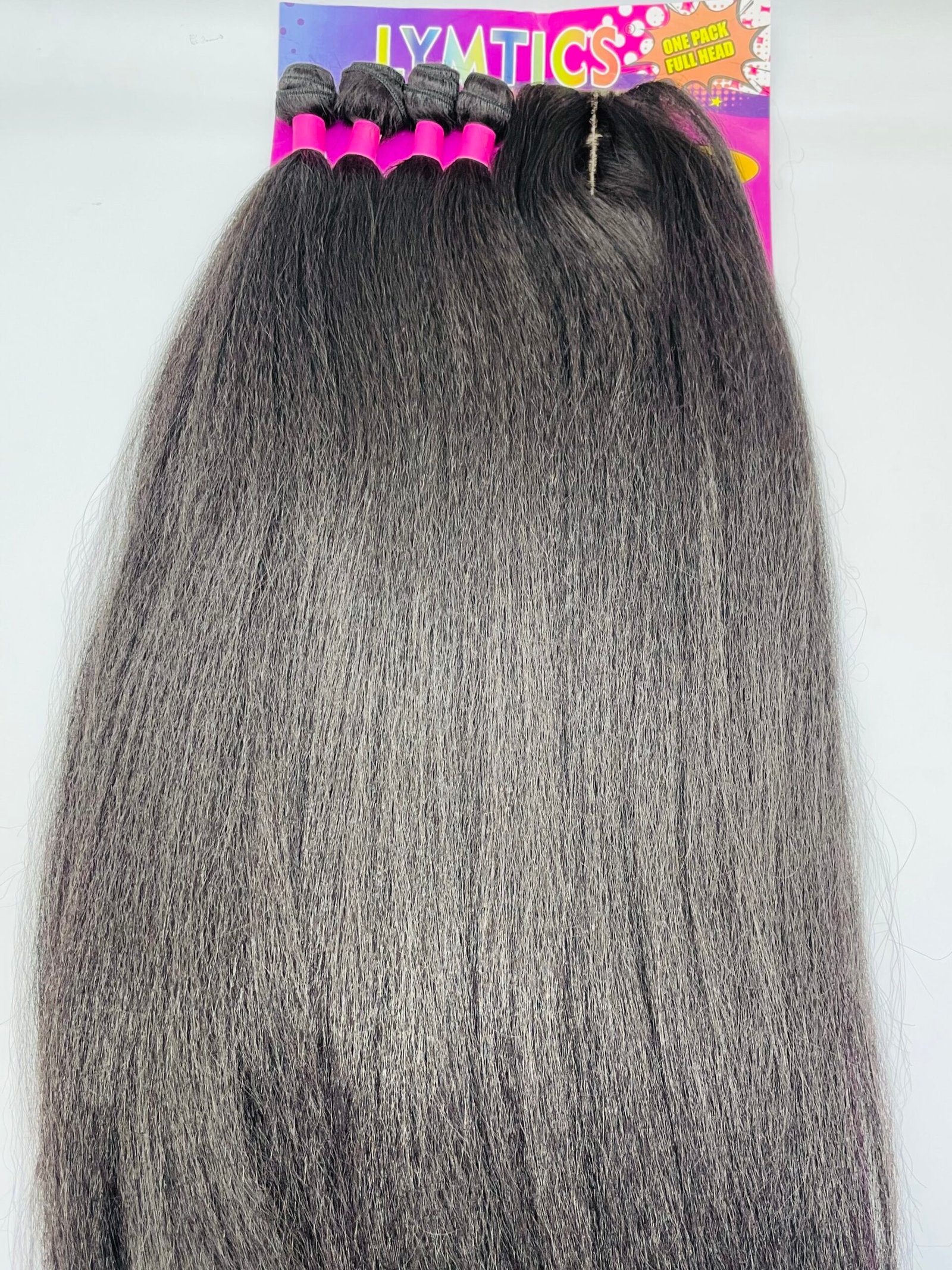 Long dark brown hair extensions with pink rollers clipped at the top, displayed in front of a colorful sign.