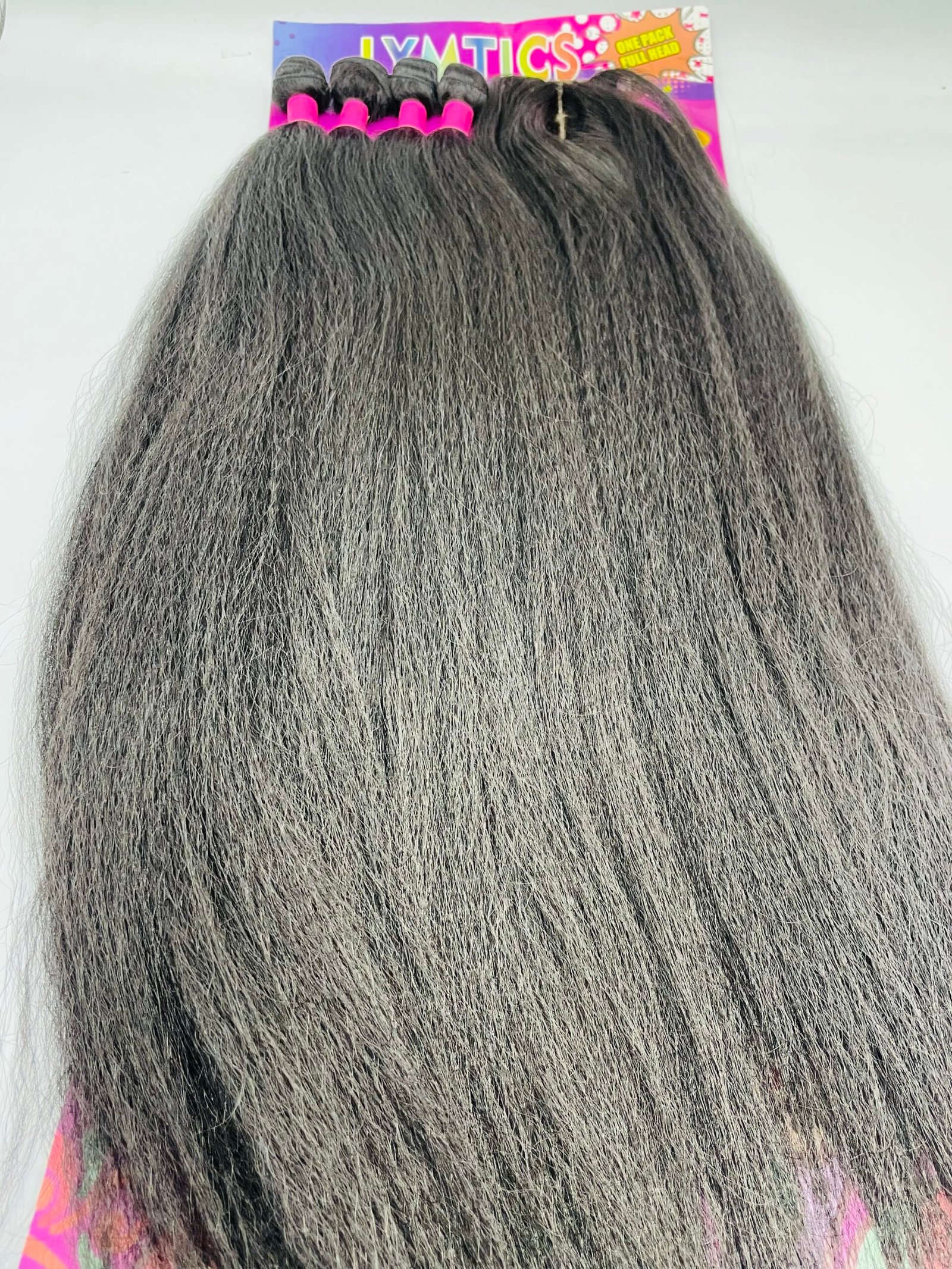 Back view of a person with long gray hair in pink hair rollers, with a colorful product package visible above the head.