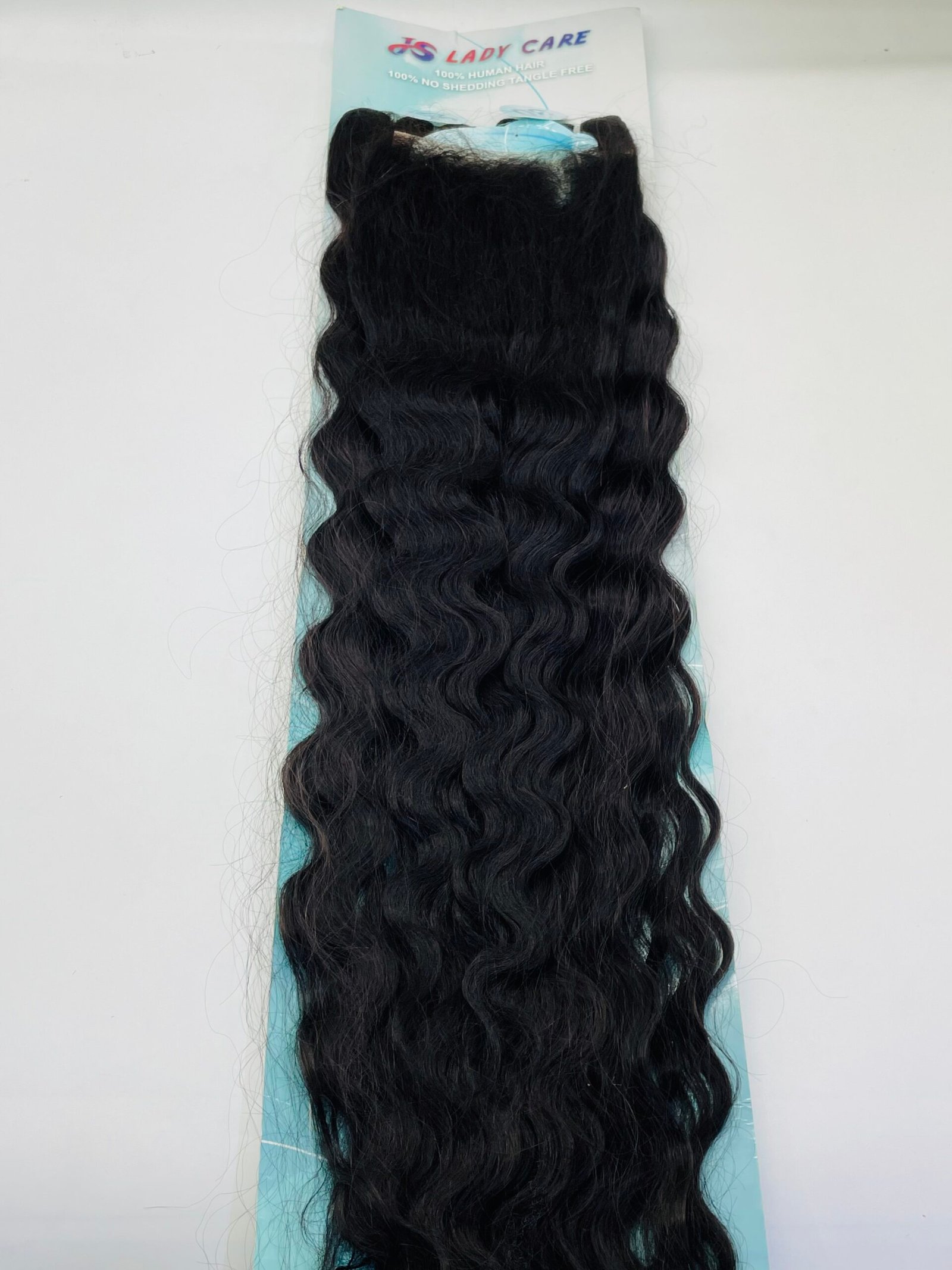 Long black wavy hair extensions mounted on a light blue backing against a pale background.