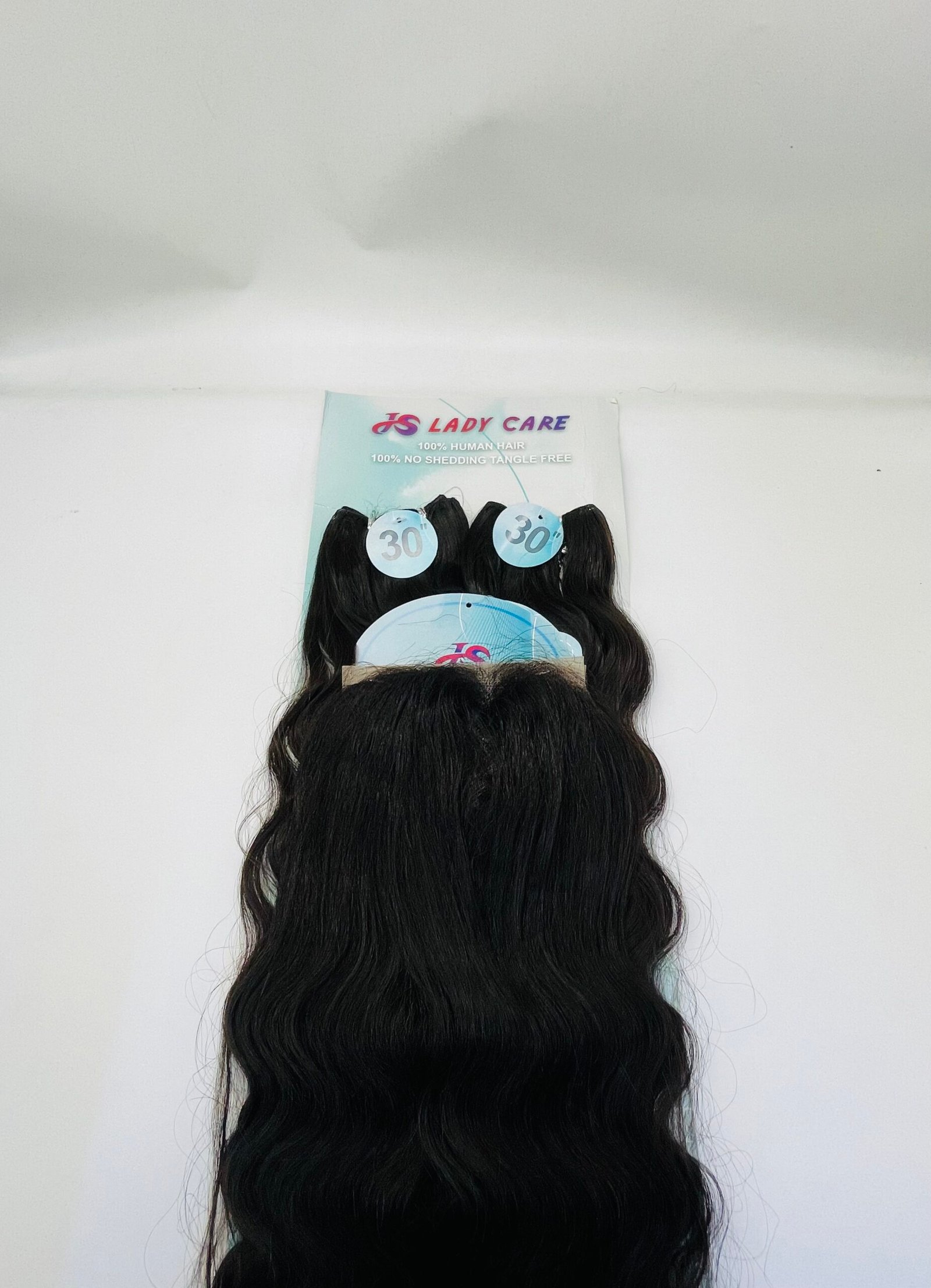 Poster on a pale wall advertising Lady Care hair with long black wavy hair extensions hanging below and circular 30" tags visible on the bundles.