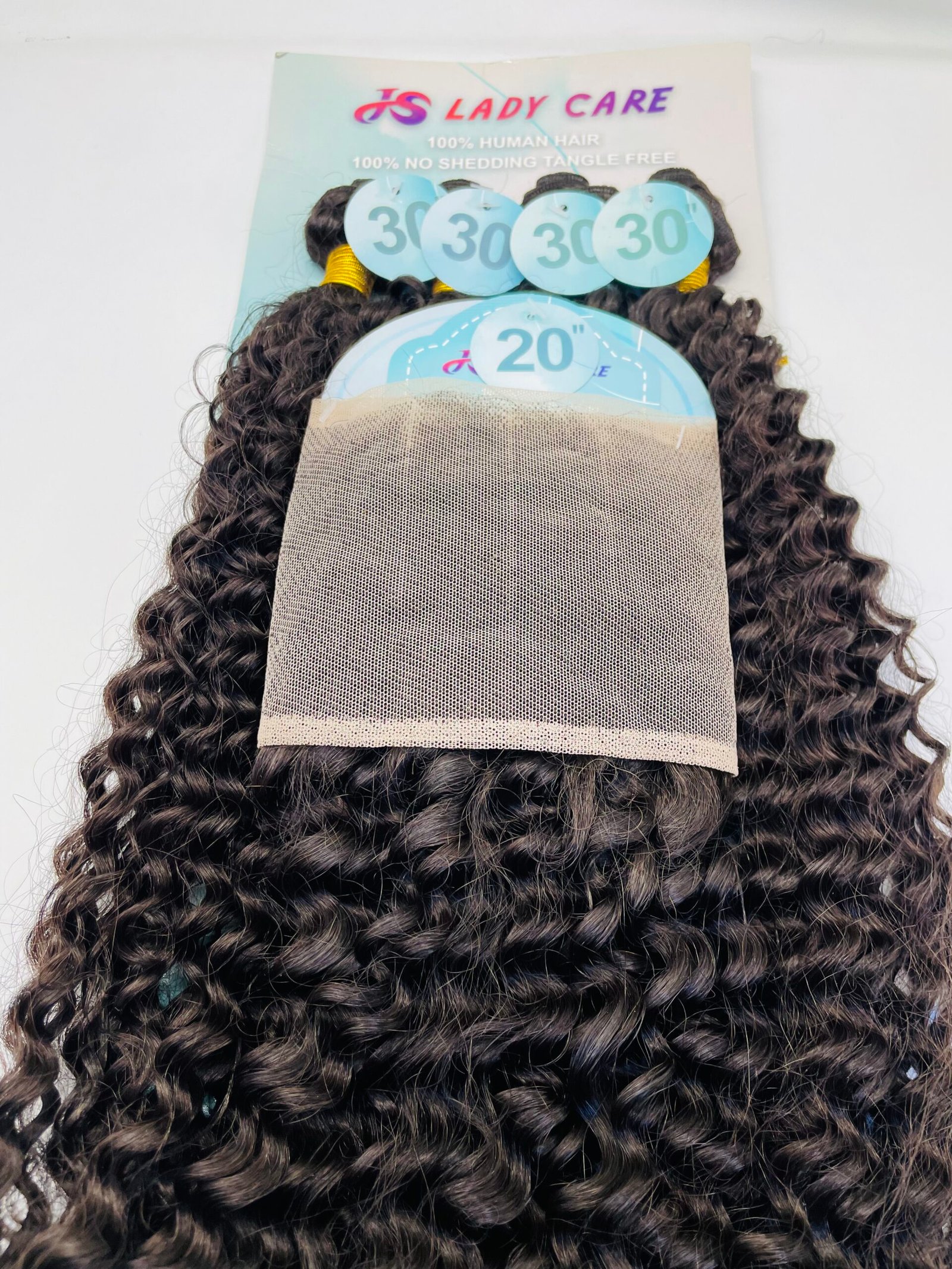 Close-up of a curly dark brown wig with a beige mesh wig cap pulled over the back of the head; blue numbered tags '20' and '30' visible.