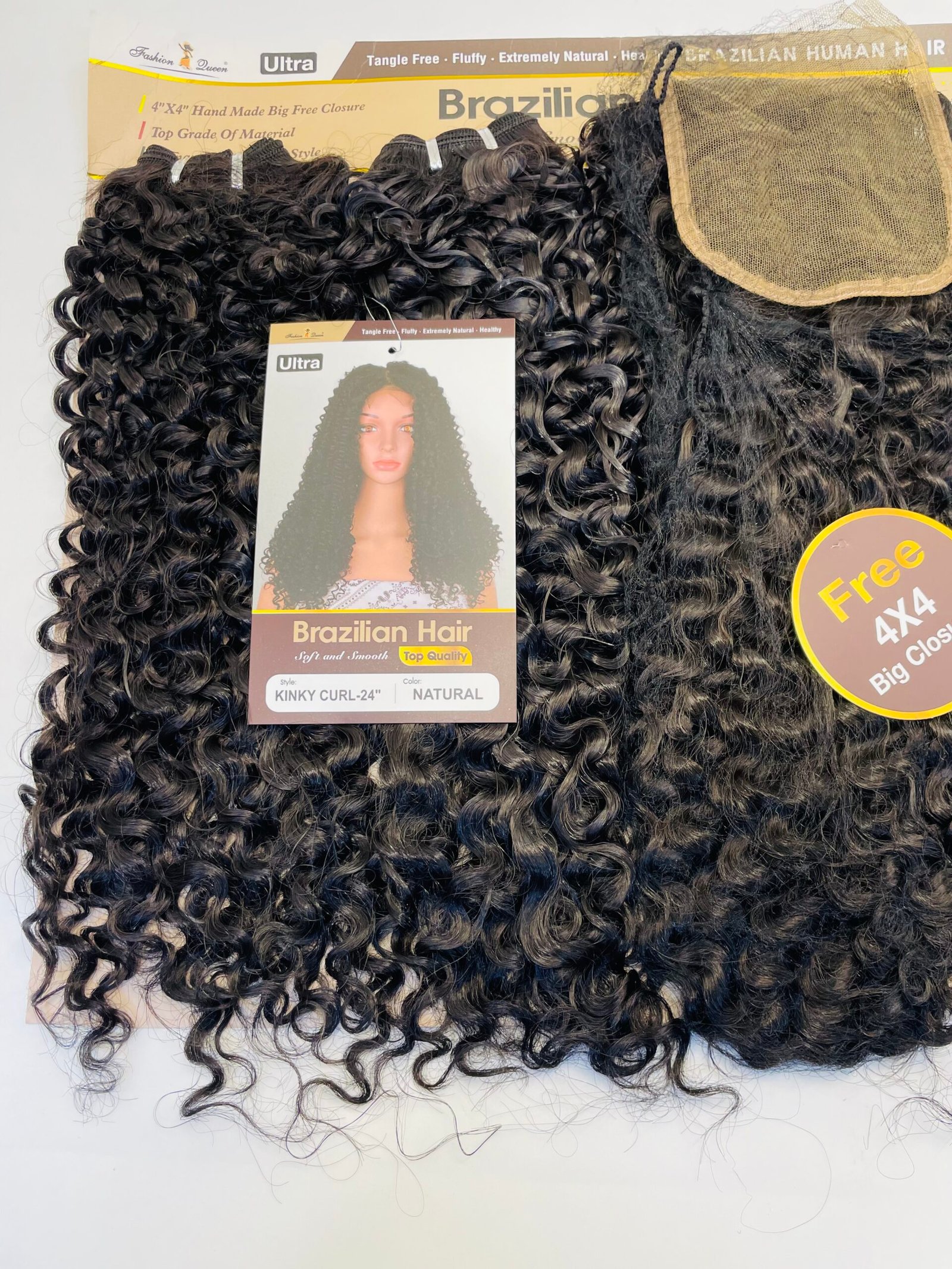 Close-up of curly black hair extensions with packaging showing 'Brazilian Hair' and a model image on the label.