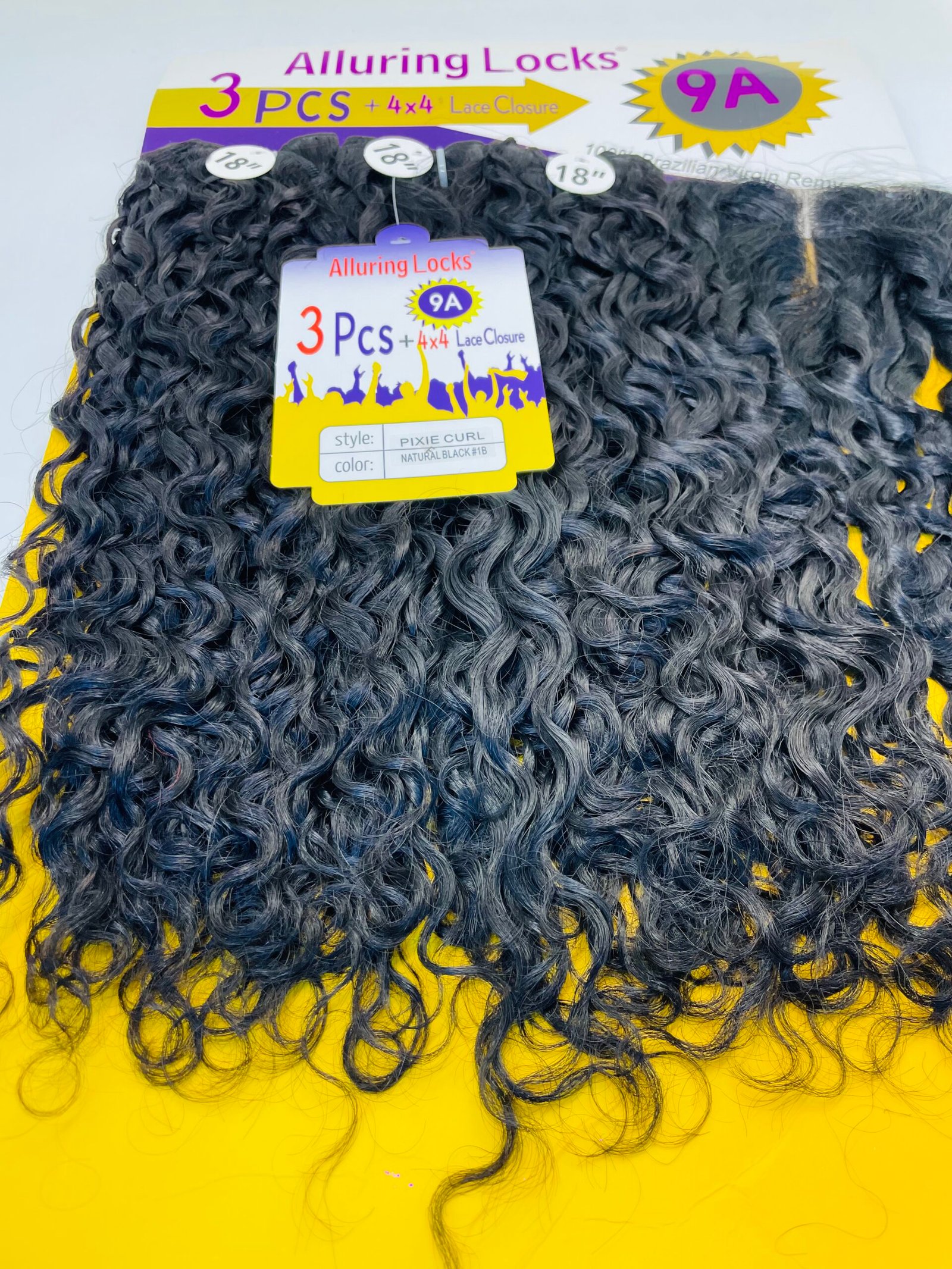 Close-up of curly black hair extensions with a yellow product tag reading Alluring Locks and '3 Pcs + 4x4 Lace Closure'.