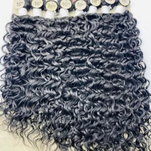 Curly black hair extensions on a display card with 16" and 18" length labels and a beige brand card reading 'Dejavu Brazilian Hair'.