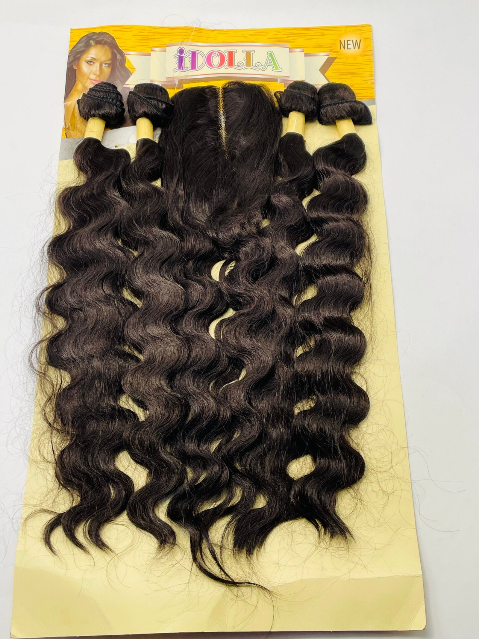 Bundle of long dark brown wavy hair extensions on a yellow display card
