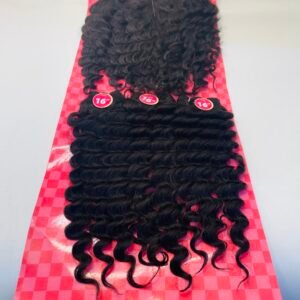 Curly black hair extensions on a pink checkerboard display, 16-inch length labels visible