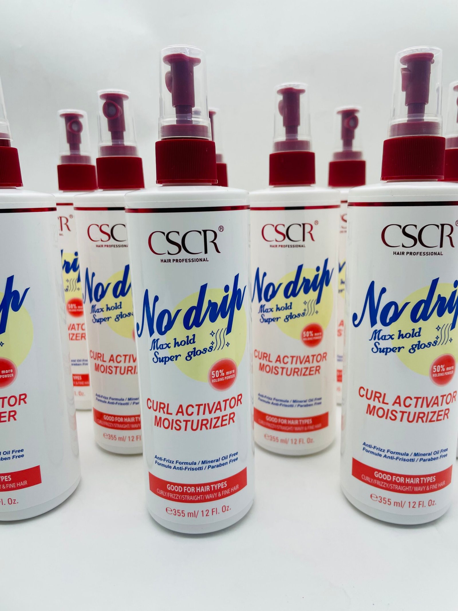Rows of CSSR No-Drip curl activator moisturizer spray bottles with red caps and white labels in a store display