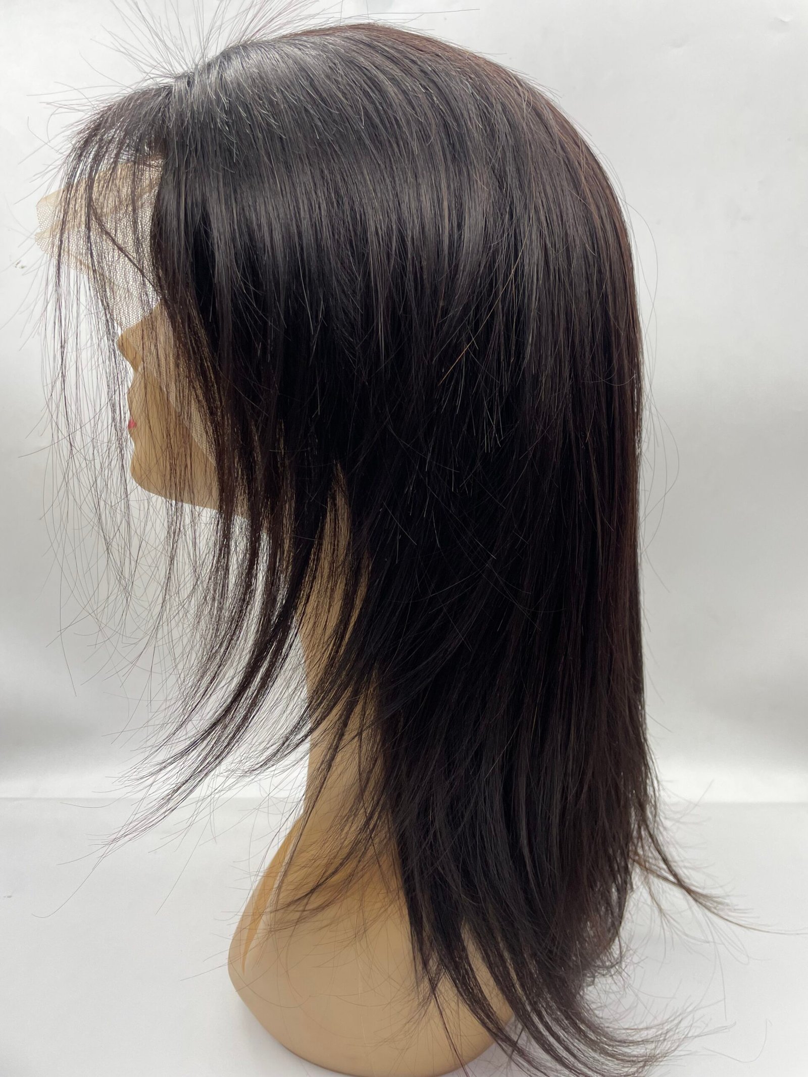 Side view of a dark brown wig on a mannequin head with straight, shiny hair and wispy ends.