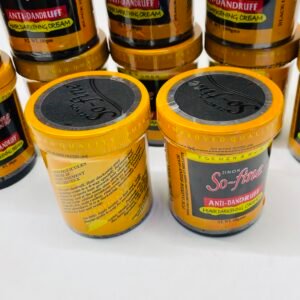 Row of orange jars labeled So-fine Anti-Dandruff Hair Darkening Cream on a store shelf.