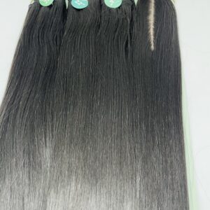 Row of long, straight black hair extension bundles on a turquoise display with green tags reading 20", 22", 24".