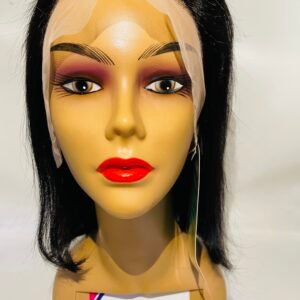 Mannequin head with black hair, wearing a sheer beige wig cap and bold makeup with red lips; label attached to the neck area.