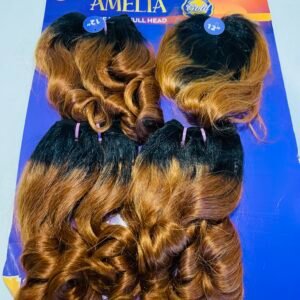 Two curled brown‑blonde wigs displayed on a blue signboard reading AMELIA above them.